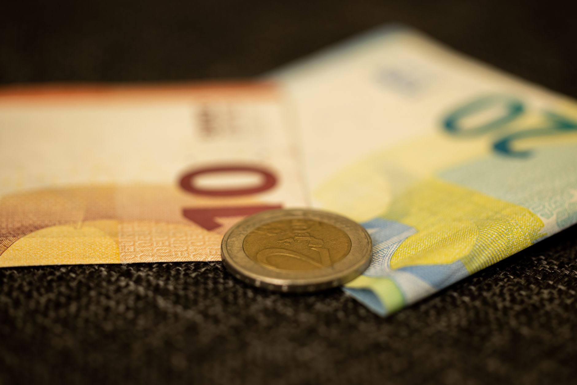a coin and paper bills in close up shot
