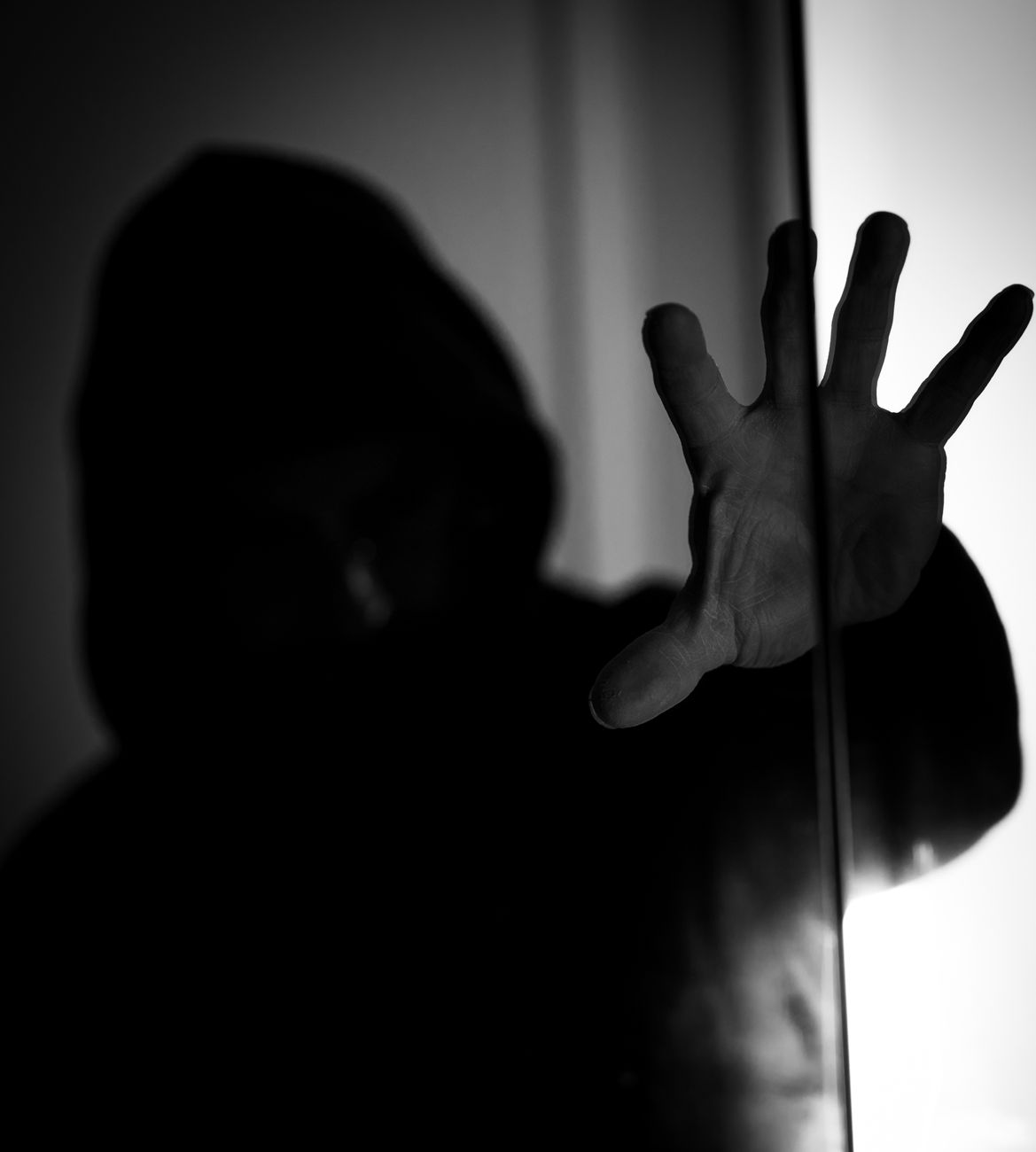hand and person in hood in darkness