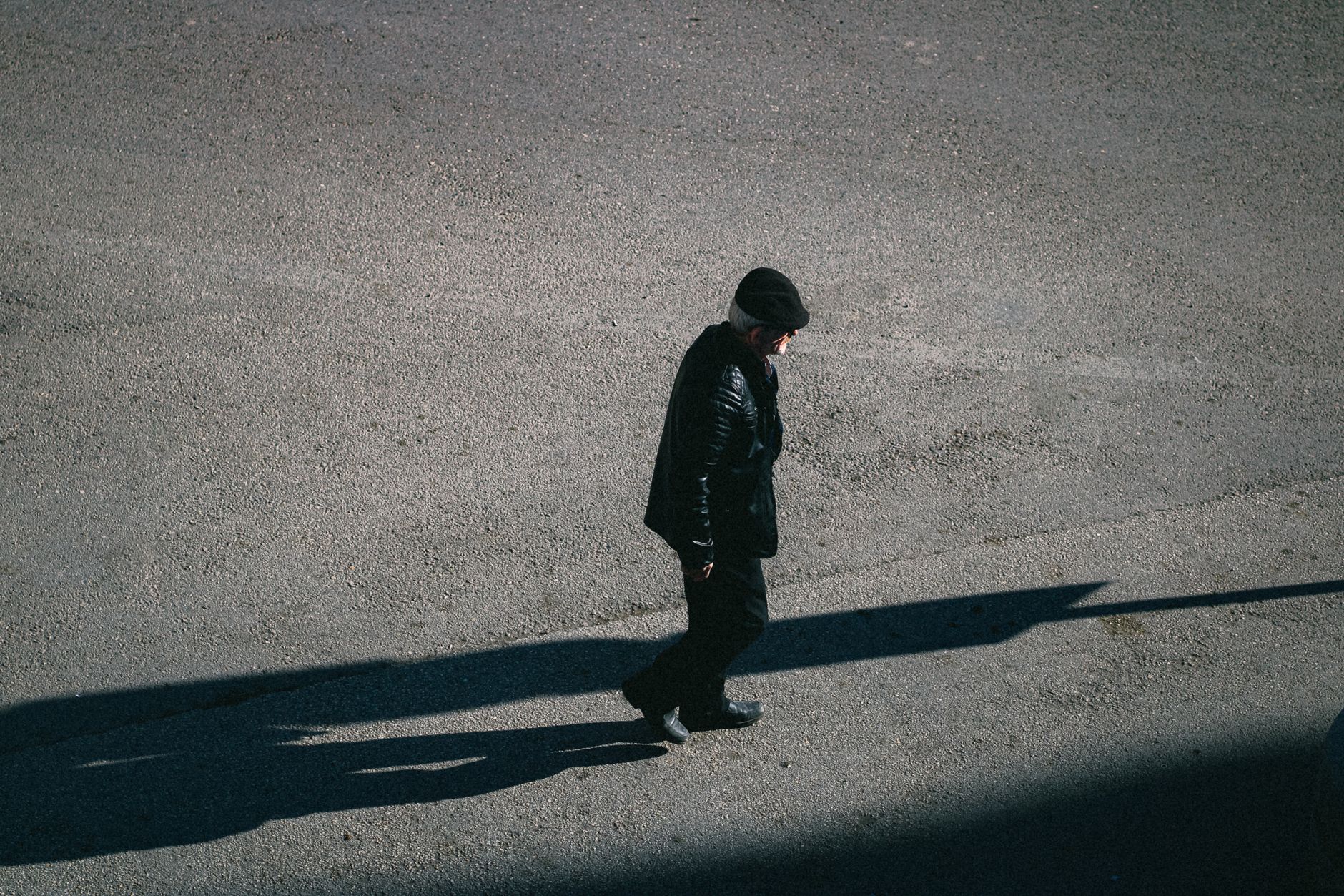 man walking alone on a sunlit street