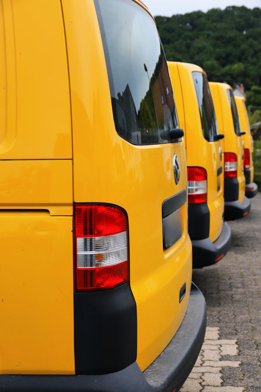 row of bright yellow vans parked outdoors