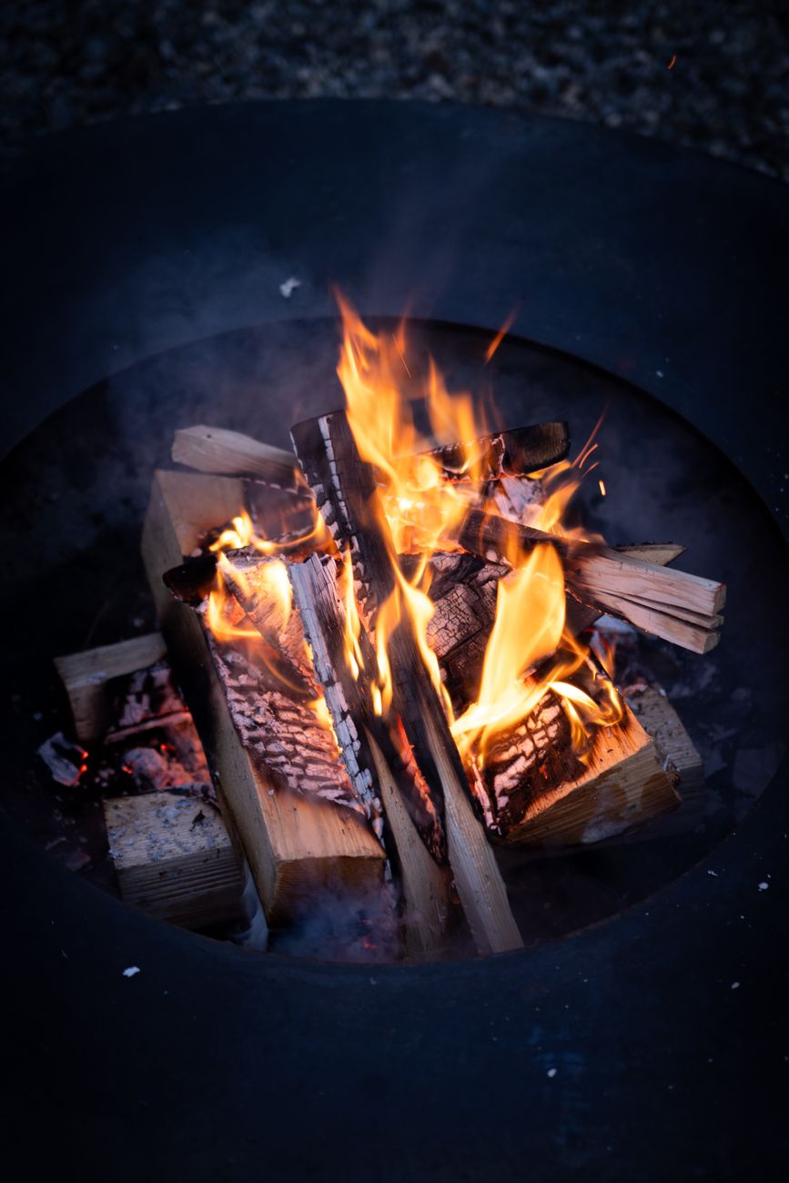 cozy fire pit with burning logs outdoors
