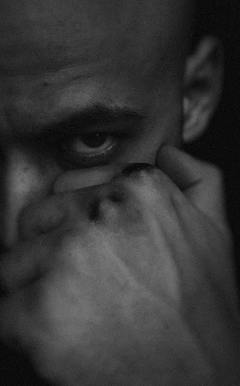 grayscale photo of person touching his face