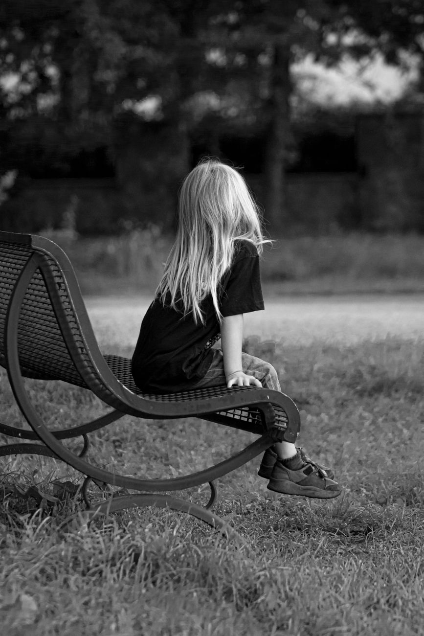 blonde girl sitting on bench