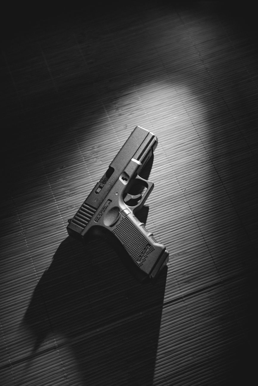 moody black and white handgun on wooden surface