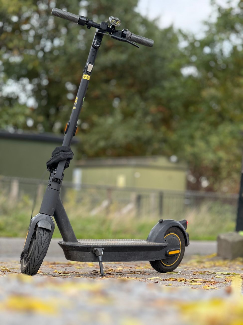 modern black electric scooter outdoors on leafy path