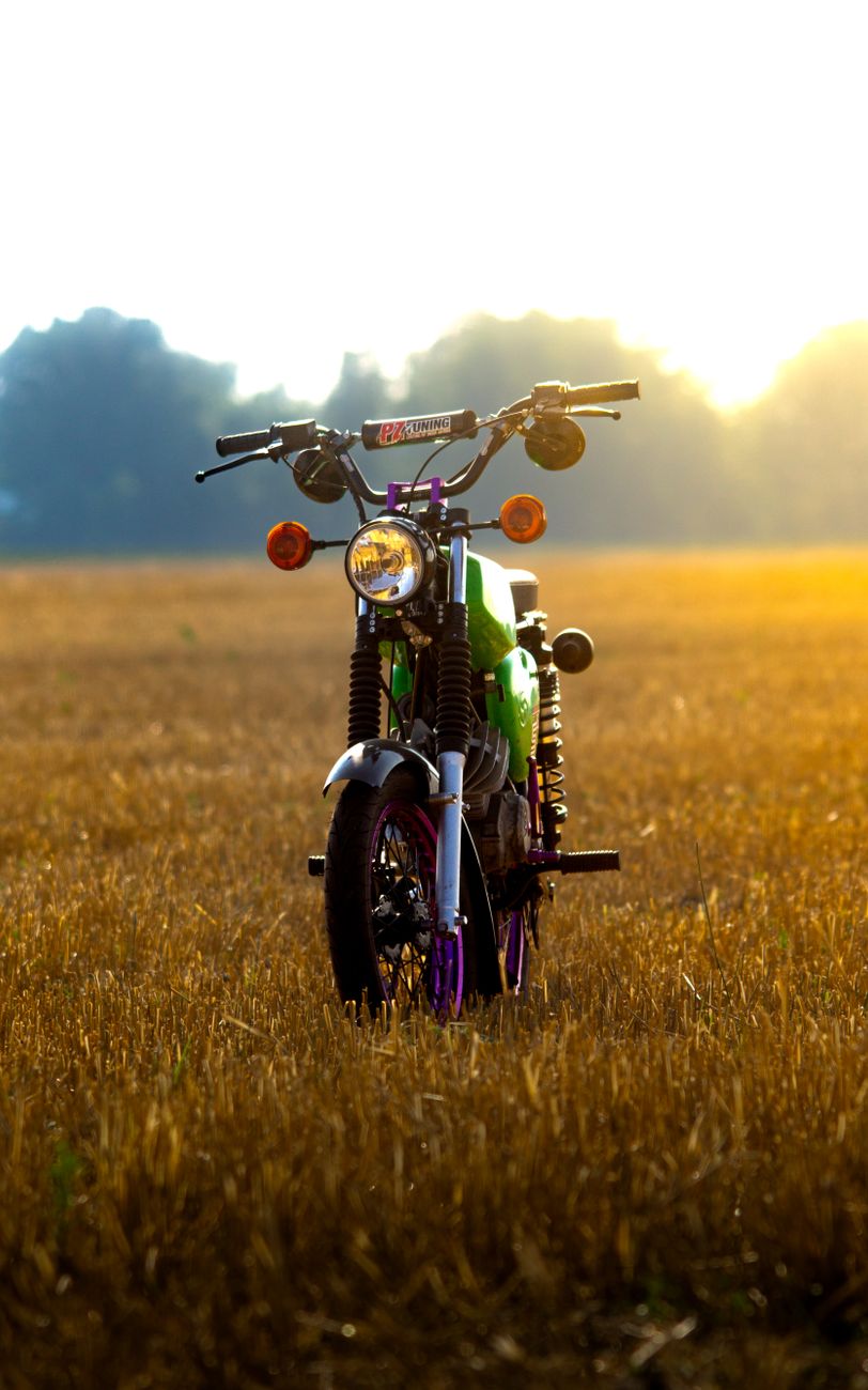 vintage motorcycle in sunlit field in schonwald