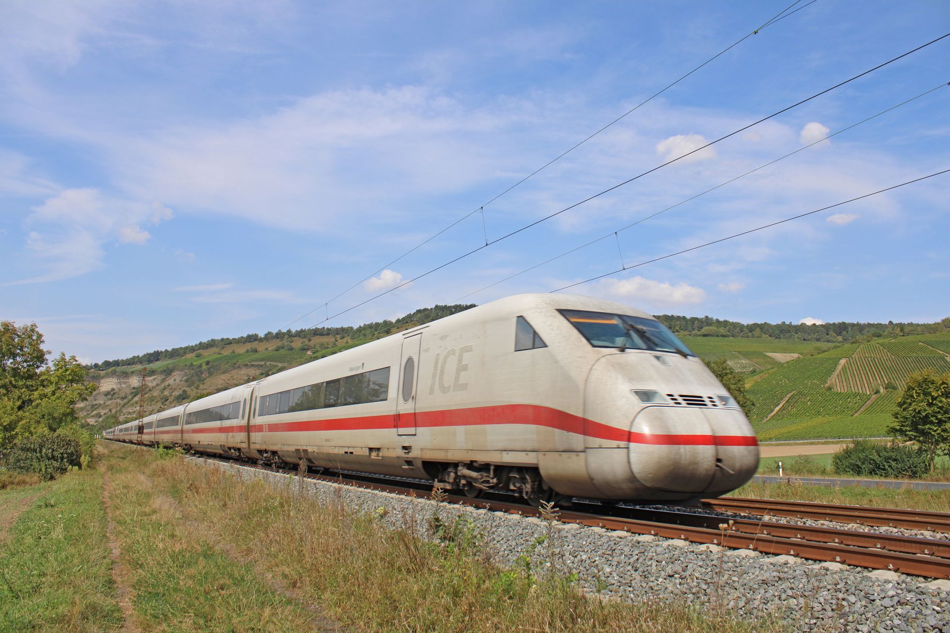 a white and red train traveling on a track